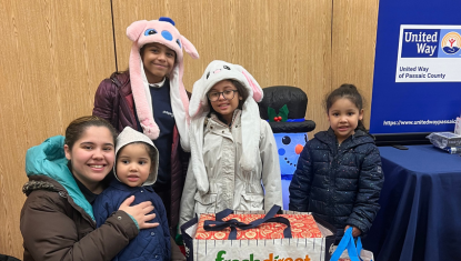 Picture of a family of 4 who received toys and cold weather gear from UWPC winter wishes drive